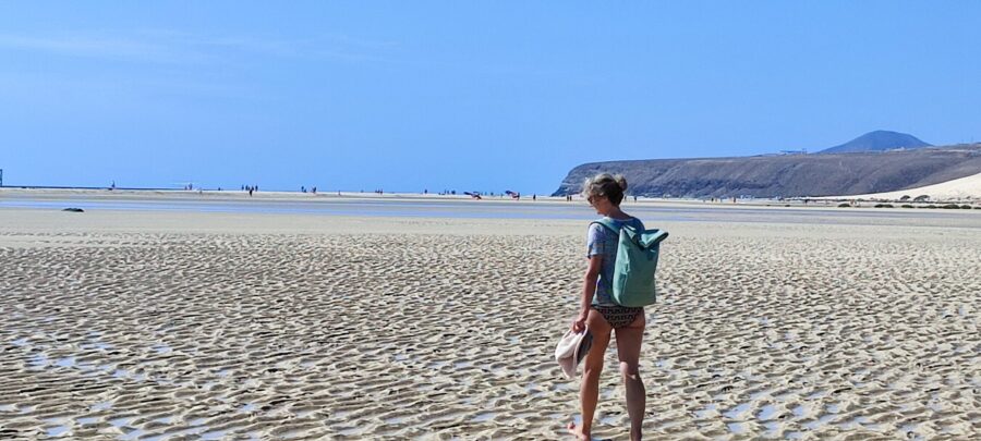 Pavlina wandert am weiten Sandstrand in Fuerteventura