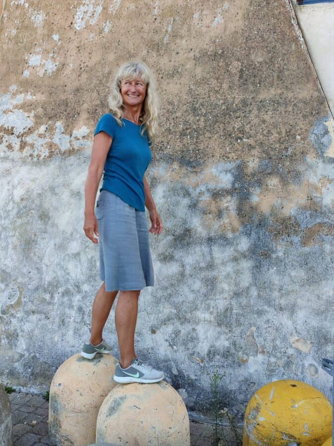 Pavlina steht lächelnd auf Betonpollern vor einer verwitterten Wand während eines persönlichen Jahresrückblicks.